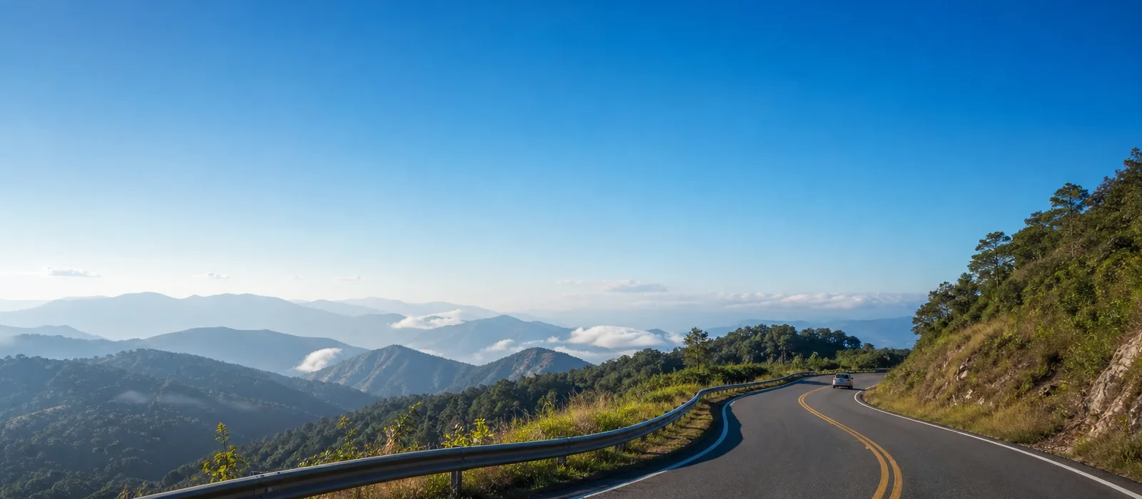 Estrada brasileira entre montanhas com um carro ao longe